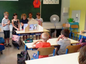 Un groupe d'enfants raconte un kamishibai à leurs compagnons