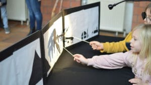 les enfants jouent avec un théâtre d'ombre