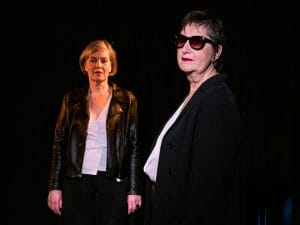 Les conteuses Christine Andrien et Italia Gaeta sont sur scène. L'une porte une veste en cuir noir et l'autre des lunettes noires.