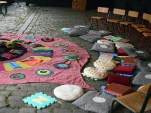 Un tapis cousu main et très coloré est posé sur le sol prêt à accueillir des enfants pour écouter des histoires.